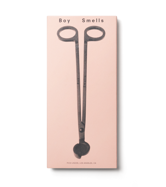 product shot of exterior pink box with black text, boy smells logo in black and black image of wick trimmer against a neutral background.